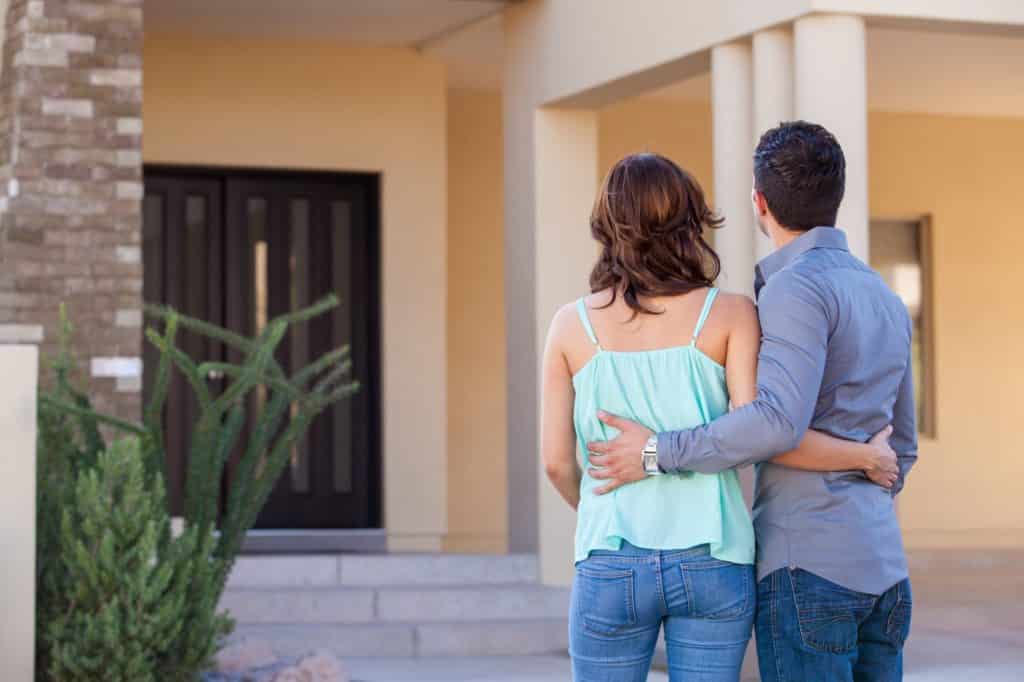 Home buying tips Couple looking at their beautifully remodeled home.