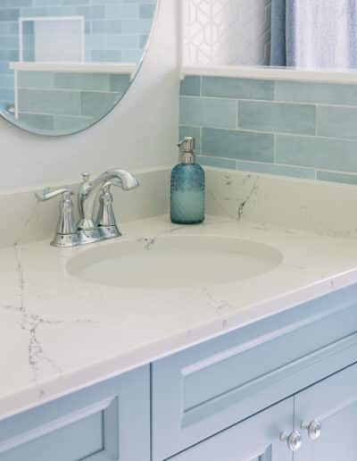 quartz countertop with chrome faucet and blue backsplash – Hughes Bath