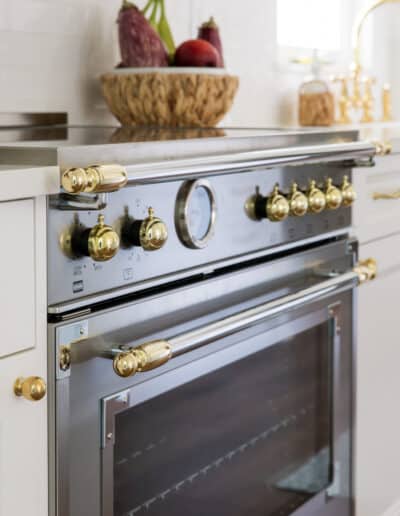 creating an open kitchen with brass-accented stainless gas range in Minnick Kitchen