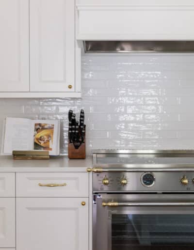 creating an open kitchen design featuring white cabinets and tile backsplash in Minnick Kitchen